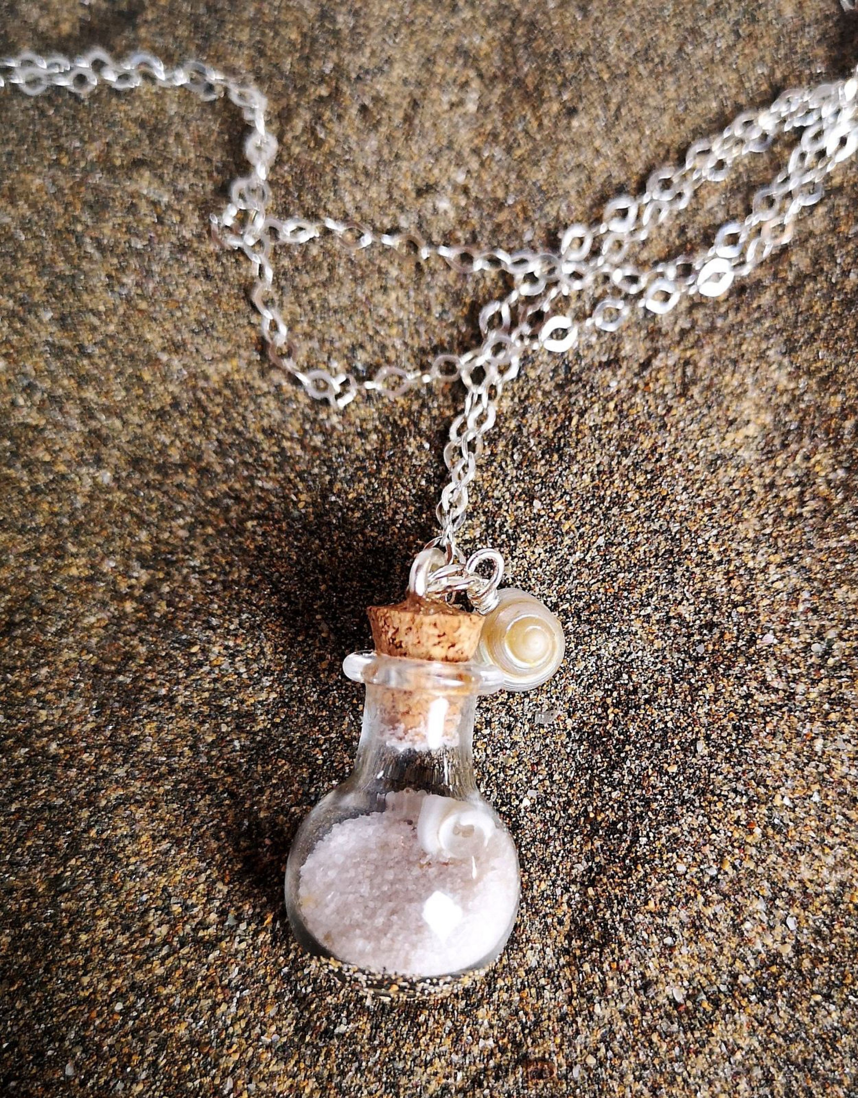 Glasflasche mit Muscheln und Sand