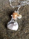 Glasflasche mit Muscheln und Sand